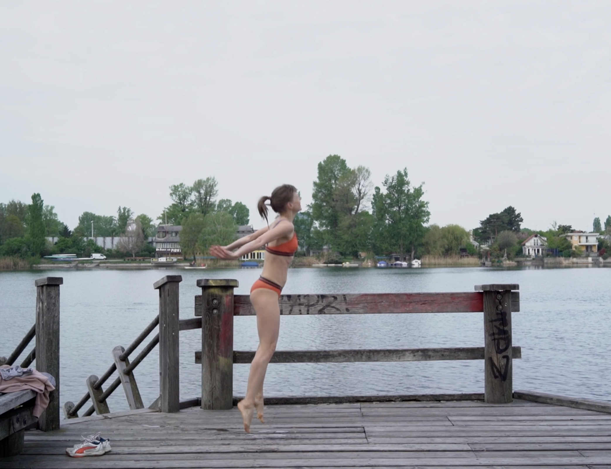 Ein Bild einer Frau im Bikino, die auf einem See in die Luft springt.